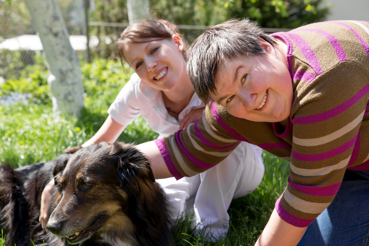 two women and a half breed dog