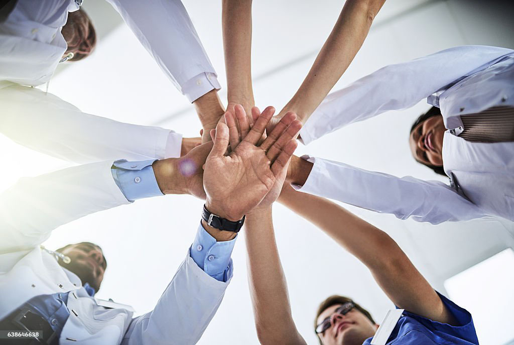 Cropped shot of a team of doctors joining their hands together in unity